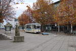 Am 12.11.2023 zeigte sich der Tw 37 der Naumburger Straßenbahn im Linienbetrieb an der Endhaltestelle am Hauptbahnhof. Links im Bild steht die markante Steinfigur  Junge Frau mit Koffer .