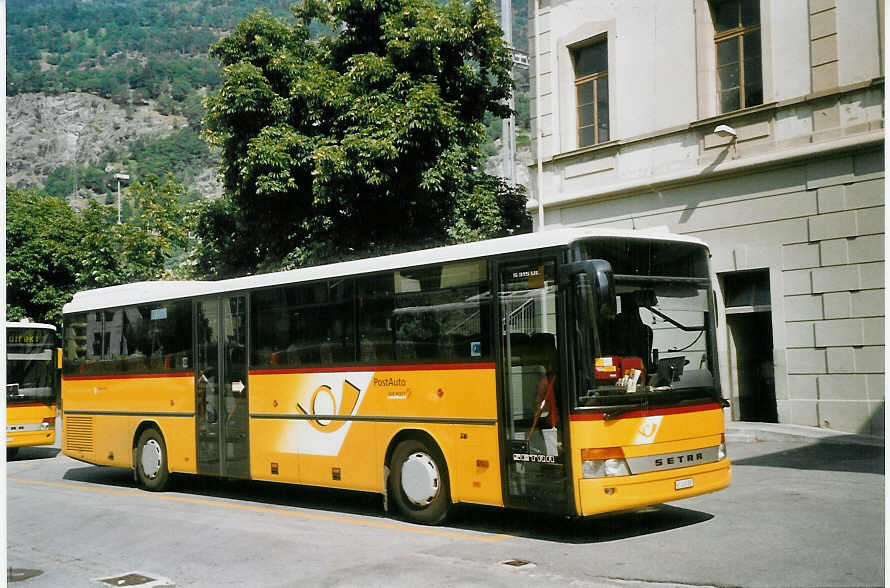 (069'735) - PostAuto Oberwallis - VS 245'887 - Setra am 31. Juli 2004 beim Bahnhof Brig