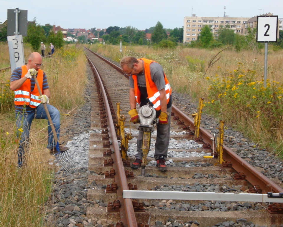 Mit viel Muskelkraft wird ein Teil des Gleises an der Roßlebener Bahnhofseinfahrt neu unterschottert; 08.08.2010 (Foto: Günther Göbel)