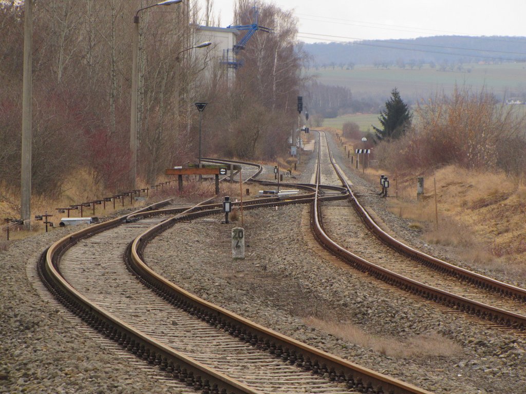 Ungewöhnliche Gleisführung zur Anschlussbahn ins Zementwerk Karsdorf. Wie man erkennen kann, wurde die Verbindung hinter dem Prellbock ausgebaut. Hier konnte man vom Gleis 5 (Bf Karsdorf) nach dem ZW über Gleis 29 in und aus dem Werkbahnhof signalmäßig Zugfahrten durchführen. Jetzt kann man nur noch als Rangierfahrt über Gleis 29 in und aus der Anschlussbahn fahren. Auch die signalmäßigen Ein- und Ausfahrten der Züge südlich (Stw ZB1 ) zum Streckengleis wurden ausgebaut. 
Das rechte Gleis ist das Streckengleis der Unstrutbahn; 19.02.2012