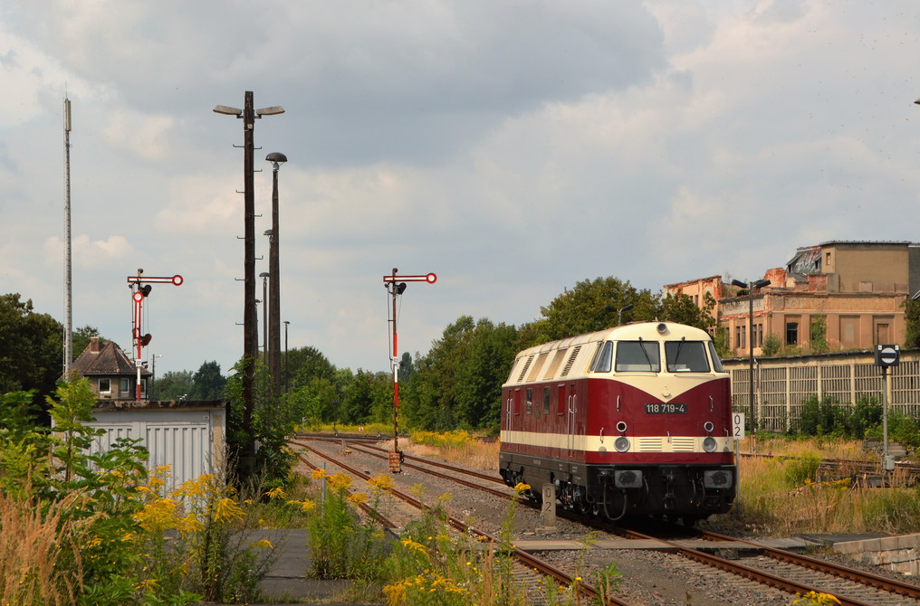 Am 14.08.2016 war die EBS 118 719-4 in Zeitz Pbf abgestellt. Im Hintergrund sieht man ein altes Fabrikgebäude der Kinderwagenfabrik Näther (VEB ZEKIWA).