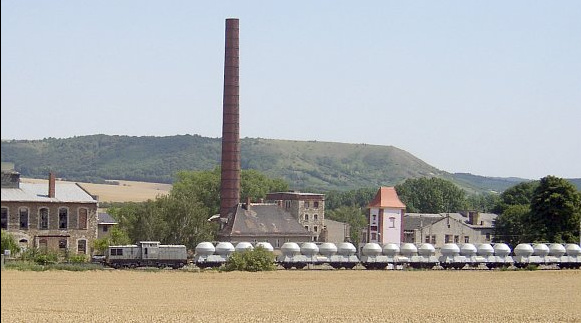 Am 16.07.2007 brachte die an InfraLeuna vermietete ALSTOM 202 001-4 leere Zementwagen nach Karsdorf. Klaus Pollmächer fotografierte den Zug vor der ehemaligen Zuckerfabrik in Laucha.