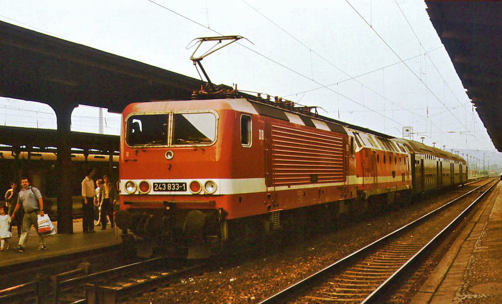 Am 20.05.1989 war die DR 243 833-1 mit einer 119er sowie Doppelstockwagen in Richtung Bad Kösen unterwegs. Markus Winter fotografierte den Zug in Naumburg Hbf.