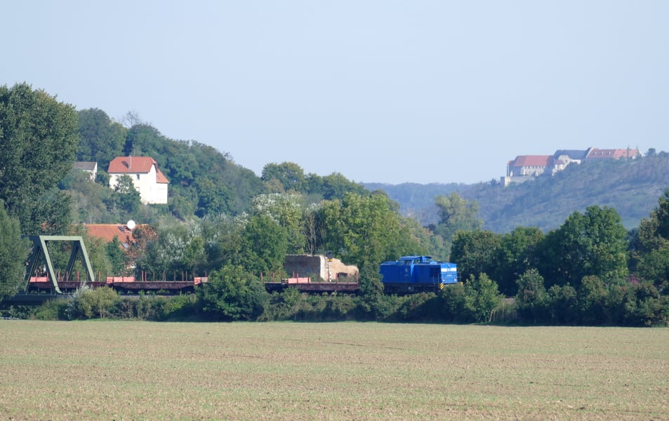 PRESS 204 033 (92 80 1202 817-3 D-PRESS) ist am 23.09.2021 mit ein paar Rungenwagen von Karsdorf nach Naumburg und dann weiter in Richtung Großkorbetha unterwegs. Die Saale bei Roßbach ist überquert.