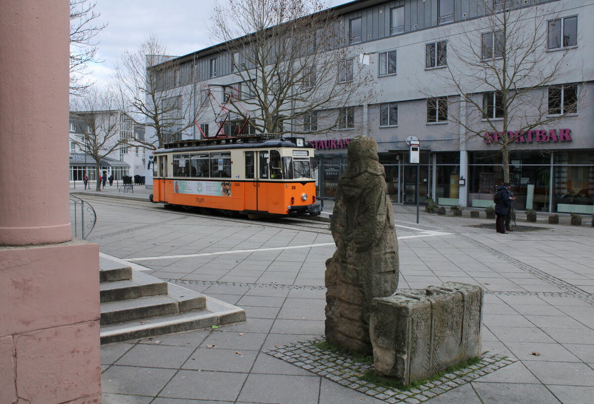 Tw 38 der Straßenbahn Naumburg als Linie 4 zum Salztor, am 03.04.2023 auf dem Vorplatz in Naumburg (S) Hbf. Die Geschichte zu der Steinfigur mit dem Koffer gibts hier nachzulesen: https://www.myheimat.de/naumburg-saale/c-gedanken/wie-die-junge-frau-mit-koffer-zum-bahnhof-kam_a2496148 