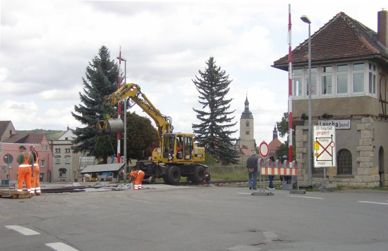Am 28.08.2007 fanden am Bahnübergang der B176 in Laucha Bauarbeiten statt. Eine Fahrbahnplatte wird mit Hilfe eines Zweiwegebaggers neben dem Stellwerk Laucha West eingeschwenkt. (Foto: Klaus Pollmächer)